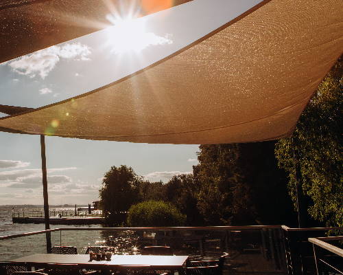 Sonnensegel über einer Terrasse am Wasser